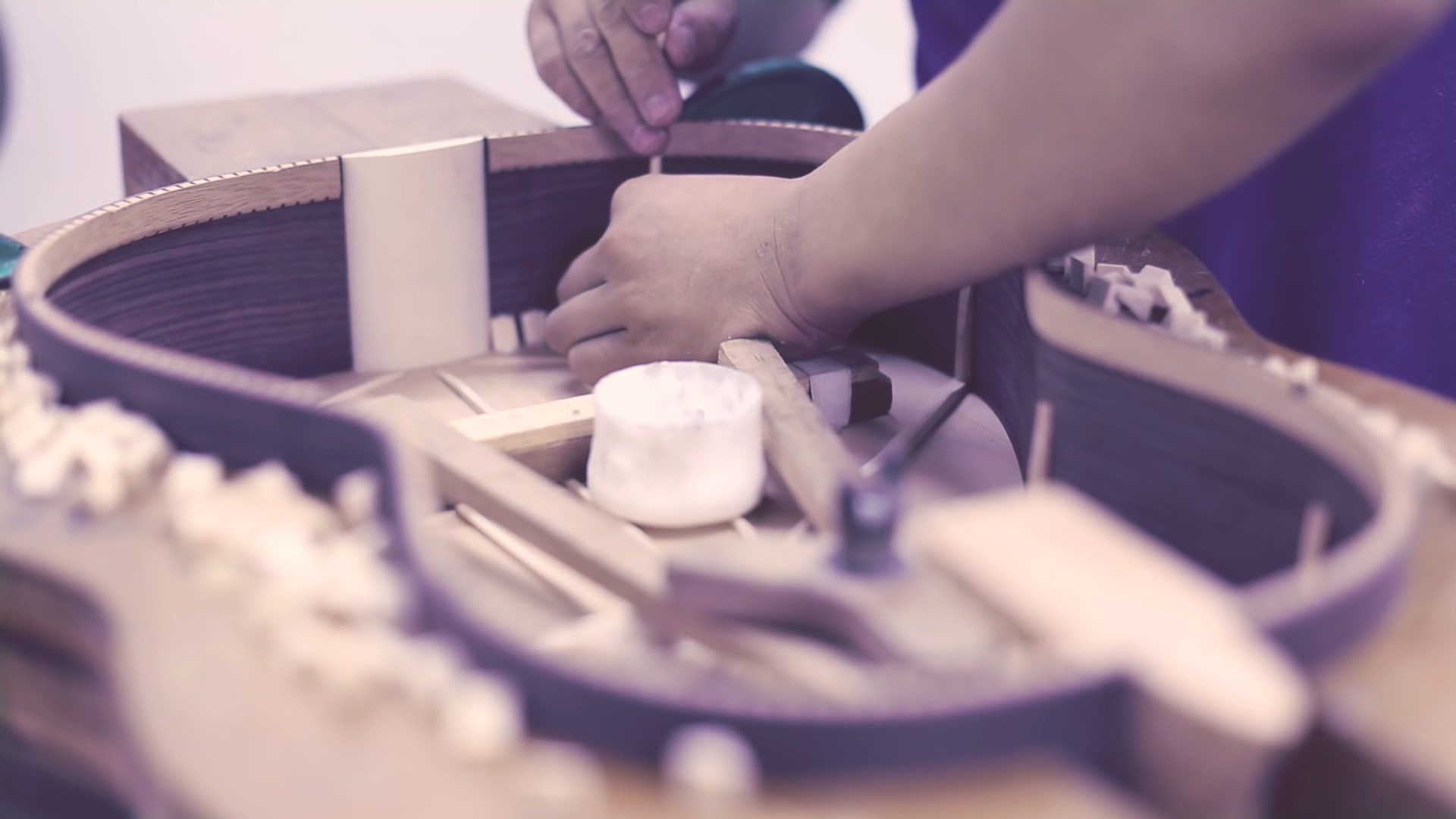 Gitarrenbauer setzt in der MARTINEZ Werkstatt von Hand die Reifchen in den Korpus einer klassischen Gitarre ein